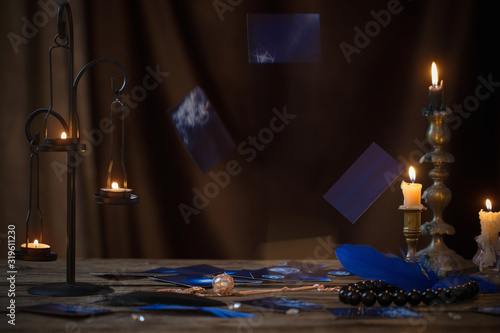 фотографія falling fortune-telling cards over  wooden table in the light of candles