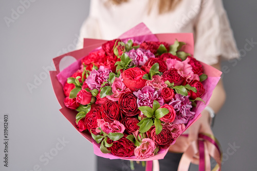 Fototapeta Naklejka Na Ścianę i Meble -  European floral shop. Beautiful bouquet of mixed flowers in womans hands. the work of the florist at a flower shop. Delivery fresh cut flower.