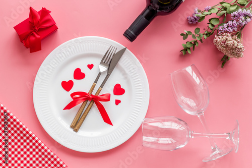 Romantic dinner on Valentines Day. Wine, plate, present box on white background top-down