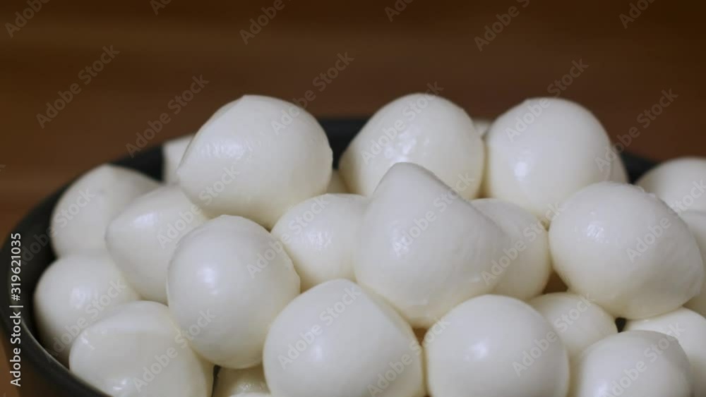 Man takes small ball mozzarella cheese Man takes small ball mozzarella cheese