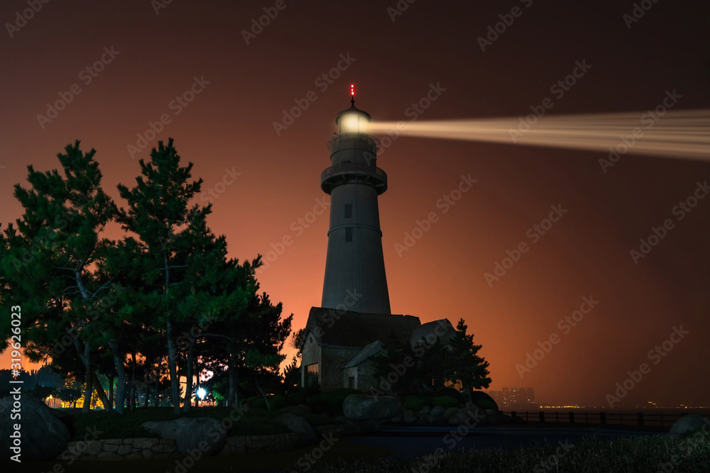 Lighthouse searchlight. Night marine embankment of Weihai