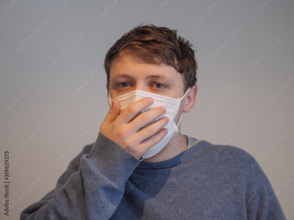 A handsome young man wearing a mask with the flu A handsome young man wearing a mask with the flu