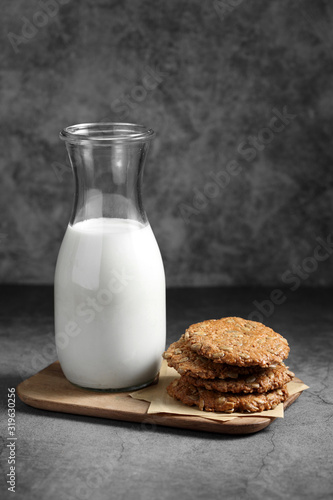 Chocolate and sunflower seed cookies with milk in glass bottle, Cookies and milk on rustic background