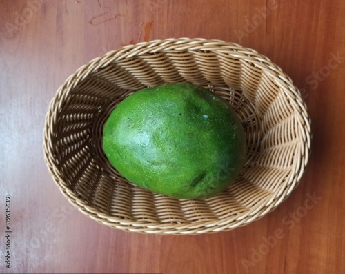 mango in wooden basket on wooden table