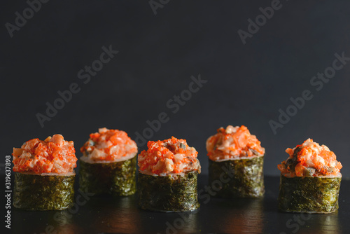 Set of five pieces of spicy Maki sushi rolls with sauced slices of smoked Eel, cheese and caviar of flying fish.