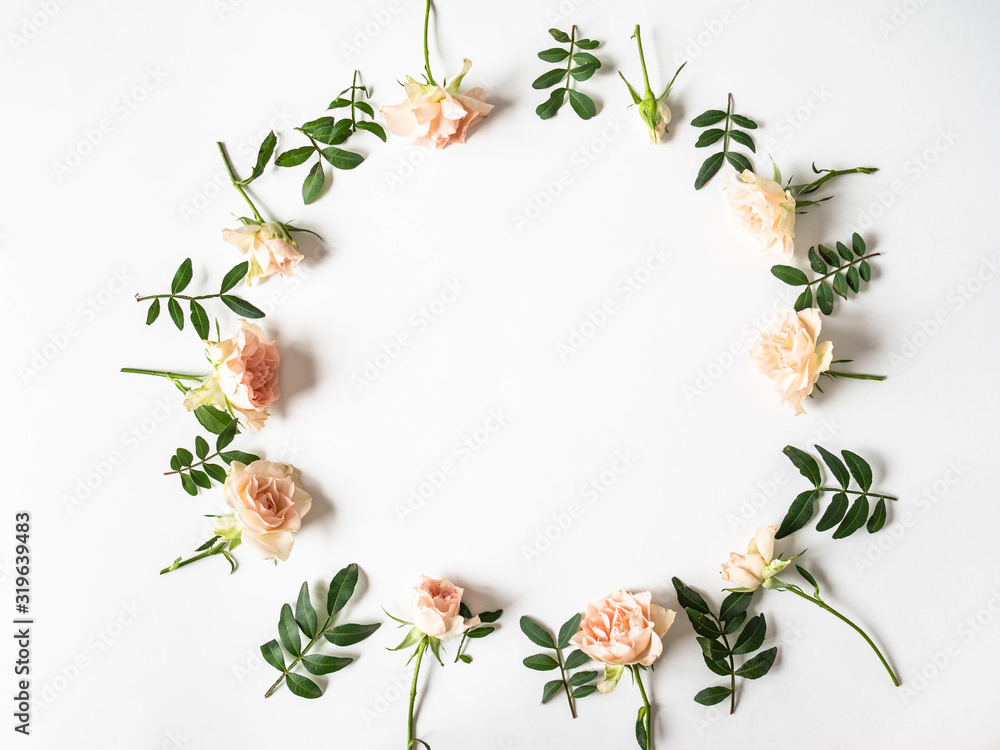 Nature creative round frame of green leaves and roses on a white background. Top view. Copy space Nature creative round frame of green leaves and roses on a white background. Top view. Copy space
