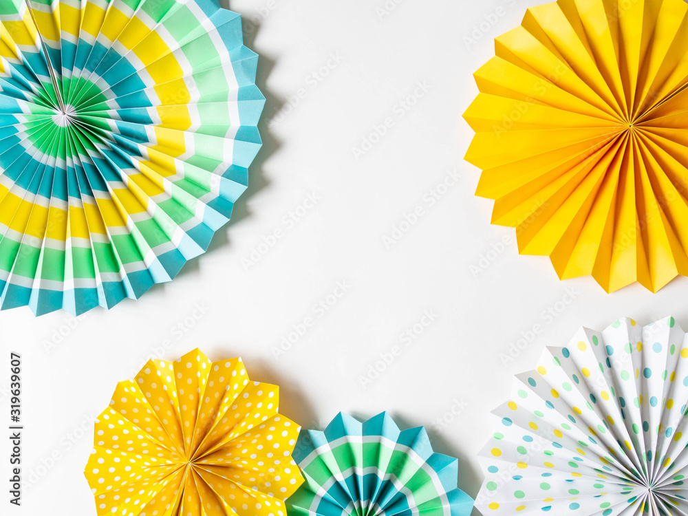 Various multicolored round paper decor for holidays and parties on white background. Top view. Copy space