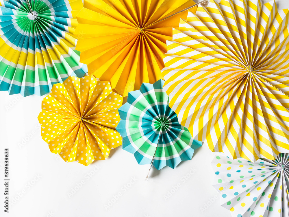 Various multicolored round paper decor for holidays and parties on a white background. Top view. Copy space