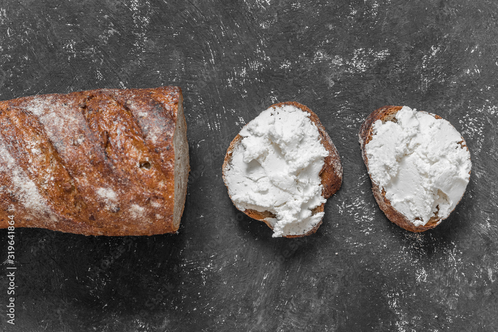 Whole grain bread bruschetta with white soft curd cream cheese on a black background. Top view. Close-up