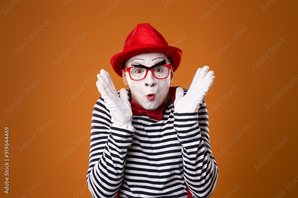 Surprised mime in red hat and vest on orange background Surprised mime in red hat and vest on orange background