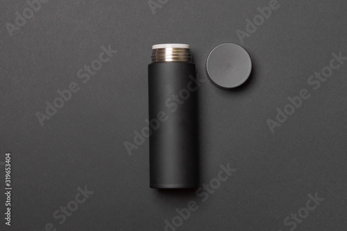 black thermos cup with open cover on black background
