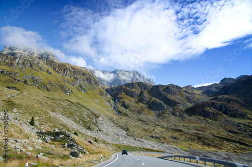 Panoramic View over Mountain Road with a Car in Switzerland.