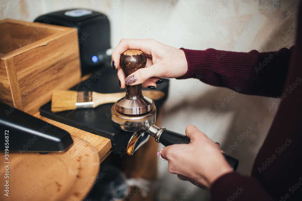 Professional coffee machine making espresso in a cafe. Bottomless filter with grind beans on a wooden black table. Roasted coffee beans. Espresso coffee extraction. Prepare of espresso.