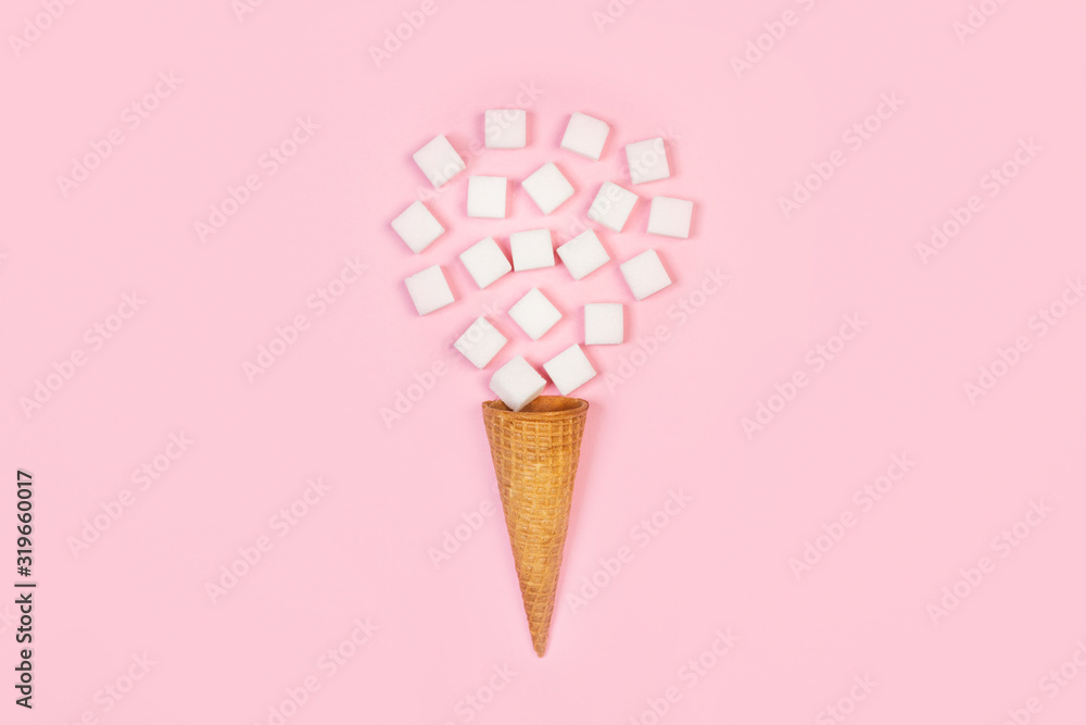 Terrones de azúcar blanco con cono de oblea sobre fondo rosa liso aislado. Vista superior. Copy space Terrones de azúcar blanco con cono de oblea sobre fondo rosa liso aislado. Vista superior. Copy space