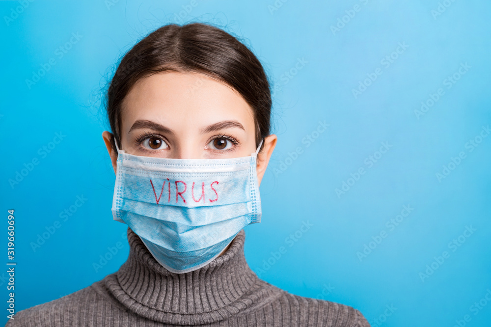 Portrait of pretty woman wearing medical mask with virus text at blue background. Coronavirus concept. Respiratory protection Portrait of pretty woman wearing medical mask with virus text at blue background. Coronavirus concept. Respiratory protection