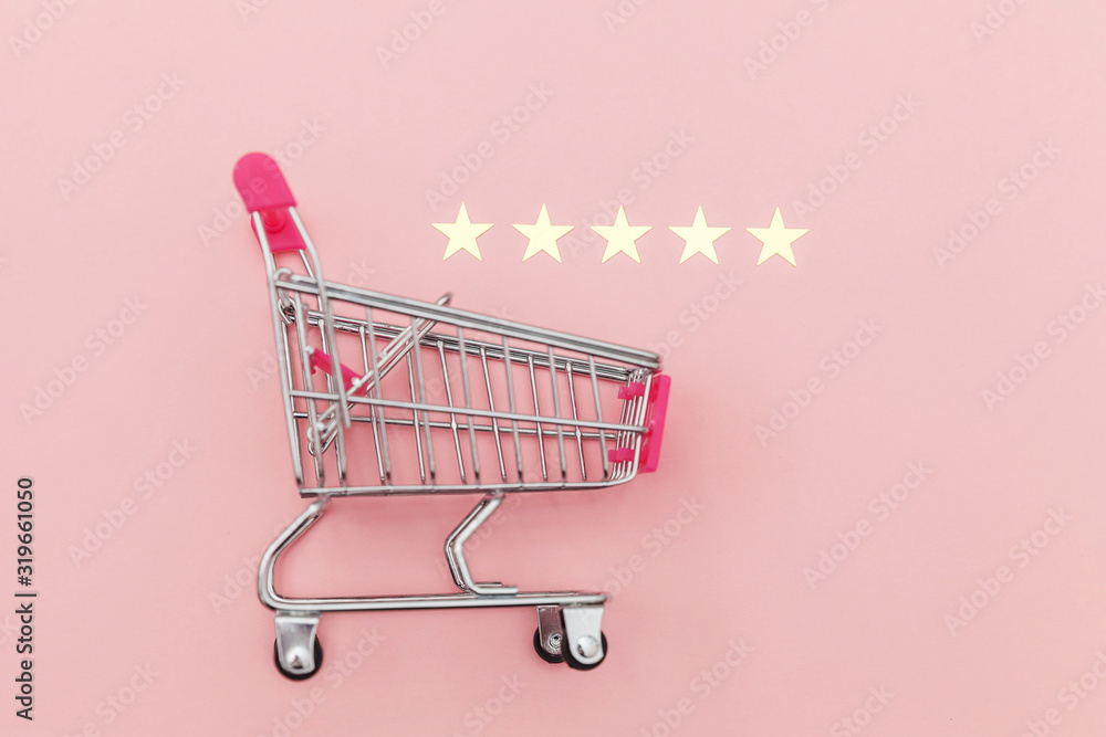 Small supermarket grocery push cart for shopping toy with wheels and 5 stars rating isolated on pastel pink background. Retail consumer buying online assessment and review concept. Small supermarket grocery push cart for shopping toy with wheels and 5 stars rating isolated on pastel pink background. Retail consumer buying online assessment and review concept.