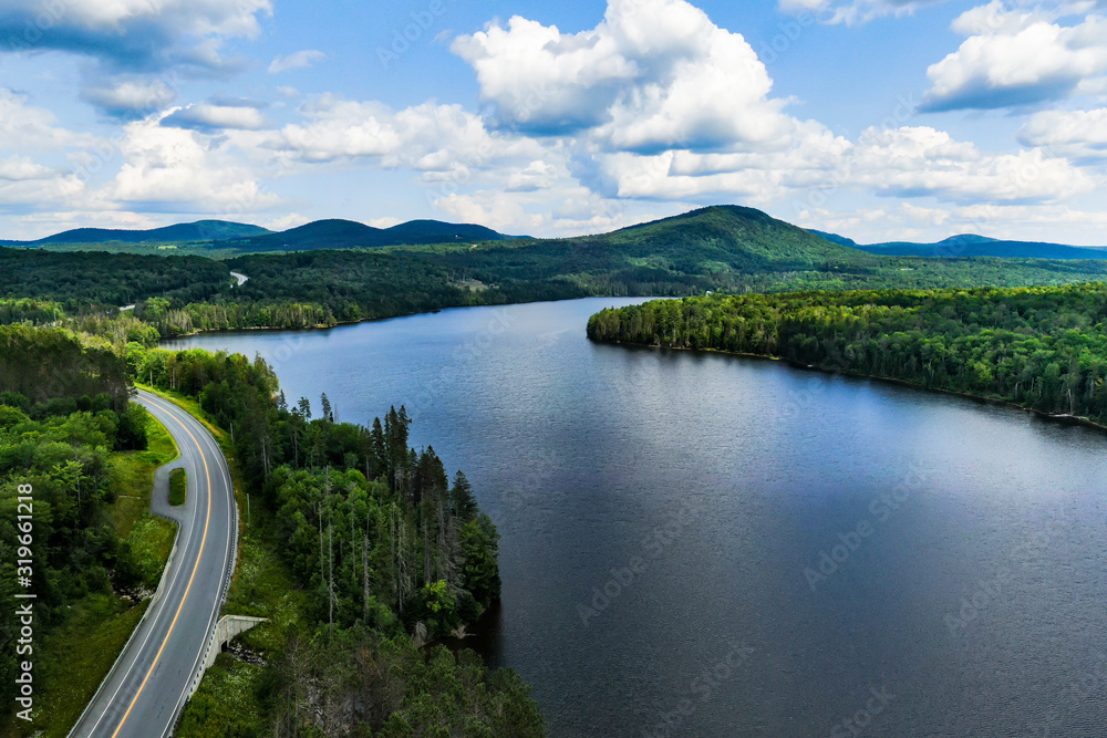 Aerial photography of Vermont`s landscape. Winding roads, embraced by green and pure nature, lakes and mountains.