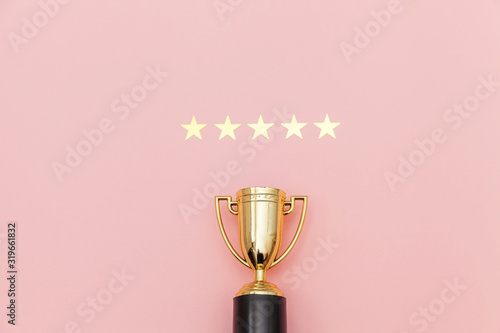 Valokuvatapetti Simply flat lay design winner or champion gold trophy cup and 5 stars rating isolated on pink pastel background