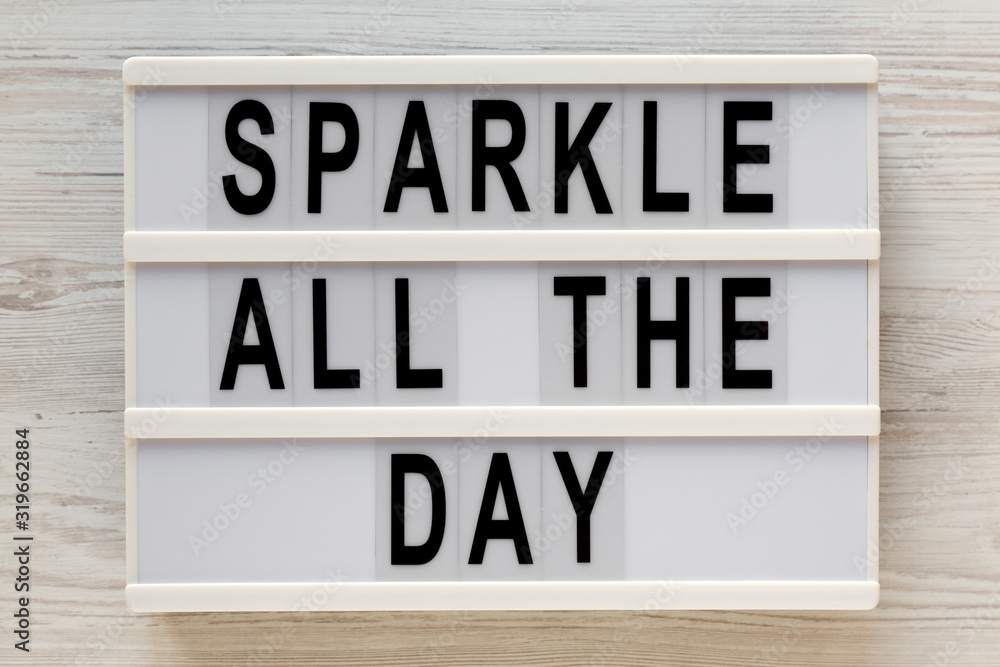 'Sparkle all the day' words on a lightbox on a white wooden surface, top view. Overhead, from above, flat lay. Close-up. 'Sparkle all the day' words on a lightbox on a white wooden surface, top view. Overhead, from above, flat lay. Close-up.