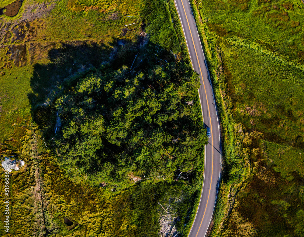 Aerial shot of winding roads, embraced by marshlands and wilderness along the coastline of Maine, USA.