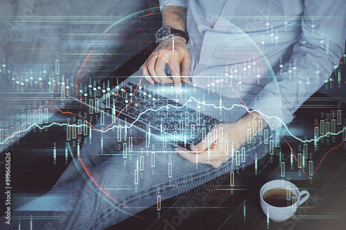 Forex graph with businessman working on computer in office on background. Concept of analysis. Double exposure.