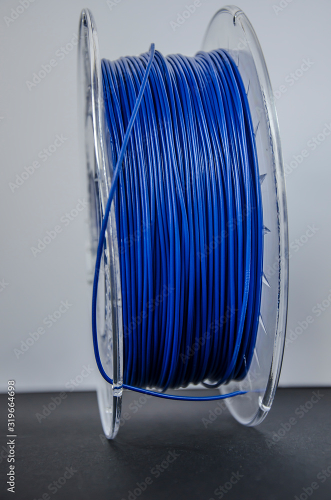 Plastic for 3D printing. Blue plastic filament, red ABS/PLA coil for 3d printer on white background, isolated - obrazy, fototapety, plakaty 