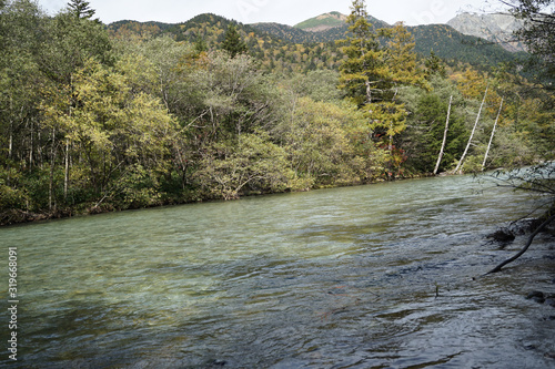 Fototapeta Naklejka Na Ścianę i Meble -  Beautiful crystal clear water river landscape with mountain background in Japan Alps Kamikochi, Nagano