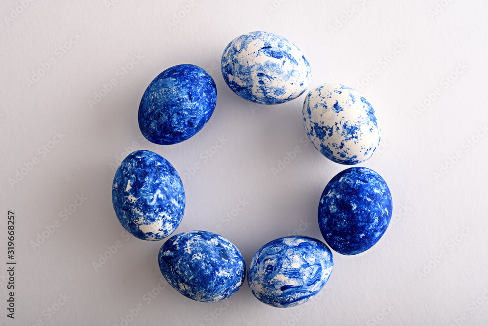 Easter eggs in the color of the year-classic blue with gradient effect are arranged in circle on white background Easter eggs in the color of the year-classic blue with gradient effect are arranged in circle on white background