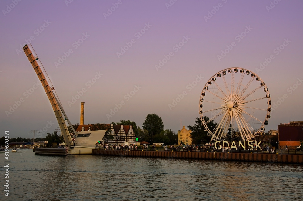 View of Ferris Wheel and lifted Footbridge over Motlawa during sunset. Gdańsk (Danzig in German) is a port city on the Baltic coast of Poland.