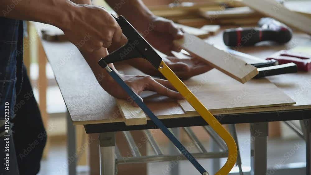 Young Asian group man worker cutting wood plank for build diy wood furniture in workshop, Slow motion footage