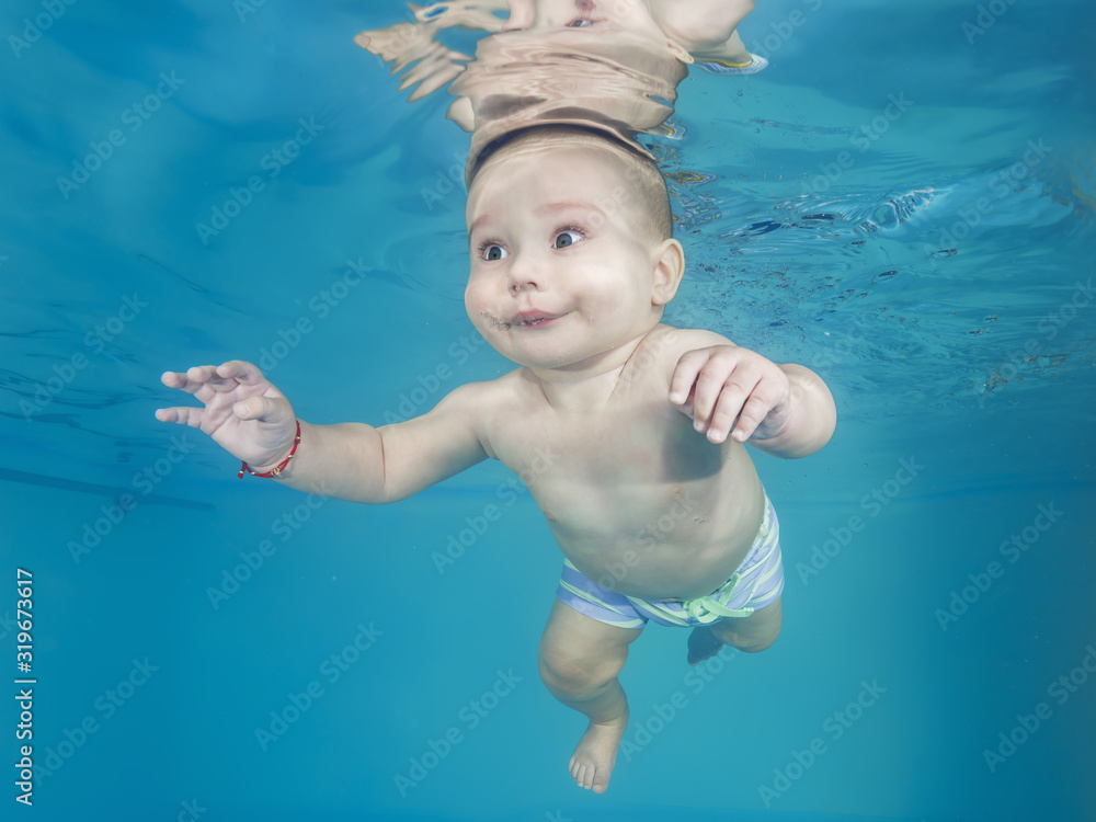 Little boy swims underwater in a swimming pool