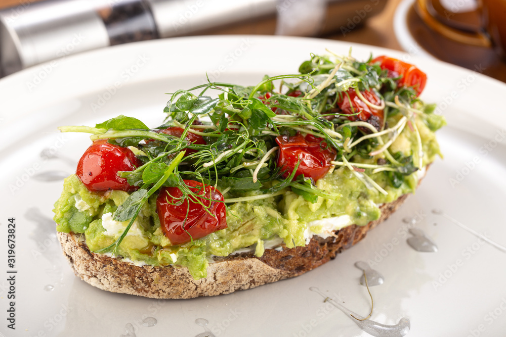 Crispy bruschetta with avocado. Useful Diet Toasts. Bruschetta with Avocado, Salmon and Cherry Tomatoes. Sandwiches with black rye bread and avocado mousse with spices
