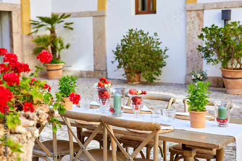 Mesa decorada con tomates y plantas en patio mediterráneo