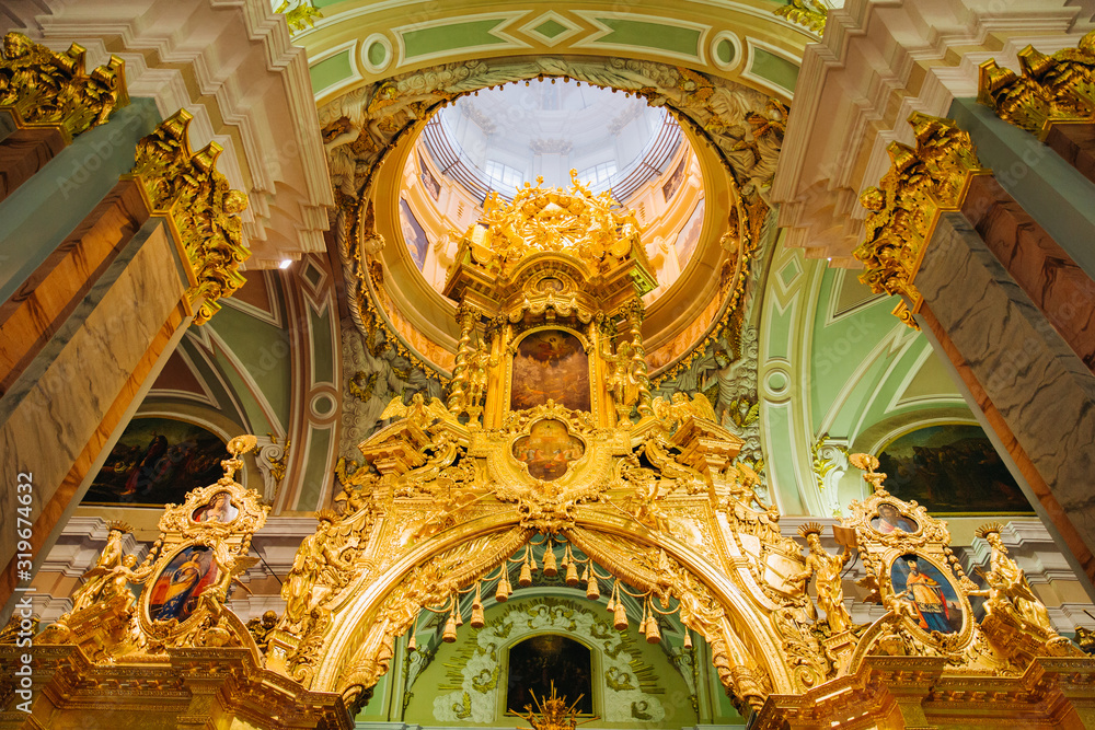 Obraz premium Icons, murals, angels and candles in the church. Golden Interior of Peter and Paul cathedral in Peter and Paul Fortress, St. Petersburg, Russia