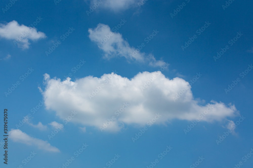 single fluffy white cloud on blue sky