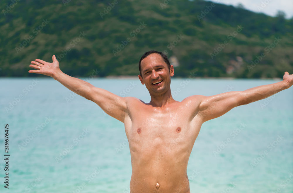 Portrait of a handsome happy man at tropical resort with smile and raised his arms up Portrait of a handsome happy man at tropical resort with smile and raised his arms up