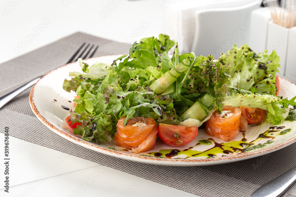 Delicious fresh salad. Salad with salmon, mozzarella cheese, cherry tomatoes, arugula, olive oil. Fresh salmon salad with mozzarella and vegetables. Close up view on Salad. Healthy, diet tasty summer Delicious fresh salad. Salad with salmon, mozzarella cheese, cherry tomatoes, arugula, olive oil. Fresh salmon salad with mozzarella and vegetables. Close up view on Salad. Healthy, diet tasty summer