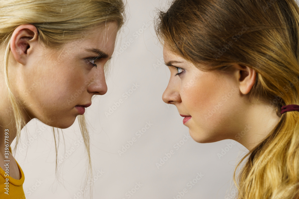 Two girls looking serious at each other. Two girls looking serious at each other.