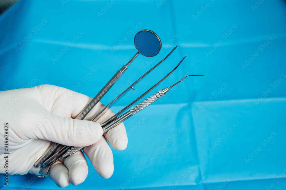 Detail of hand holding dental tools in dental clinic. Dental clinic. Detail of hand holding dental tools in dental clinic. Dental clinic.