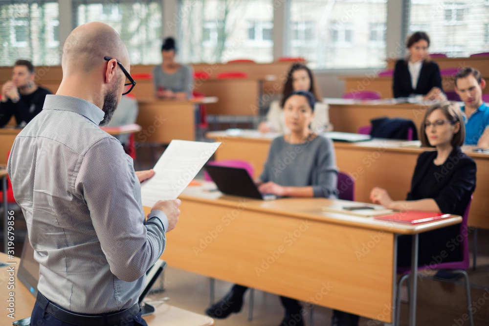 Lecturer and multinational group of students in an auditorium Lecturer and multinational group of students in an auditorium