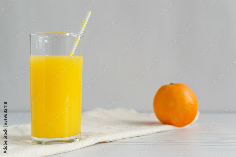 Fototapeta premium Orange juice with fruit on light wooden background