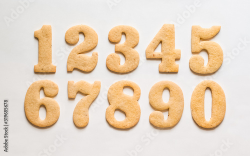 A set of sugar cookies / gingerbread cut in the form of numbers one, two, three, four, five, six, seven, eight, nine, zero on a white background.