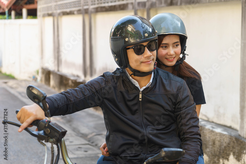 Asian couple are riding motorcycle for holiday trip.