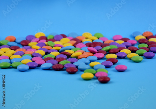 Colorful candies on a blue background stock images. Sweets isolated on a blue background. Candy on a blue background with copy space for text