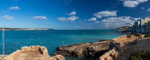 Panorama of landscape of Malta with turquoise clear water, coastline rock cliffs and residential houses