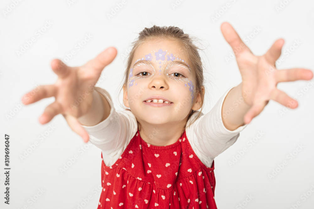 adorable kid with floral painting on face outstretching hands at camera isolated on white adorable kid with floral painting on face outstretching hands at camera isolated on white