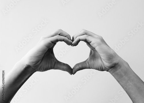 Female hands that make a heart shape. Heart shape with female hands. Close-up. Sign of love.  Black and white image