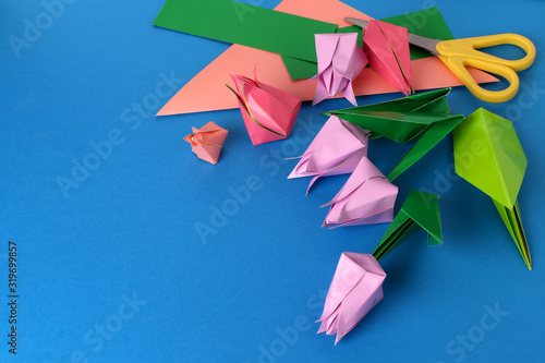 Mother's Day, happy birthday, March 8, Women's Day, Valentine's Day. Bouquet of tulips from colored paper origami on a blue background. Greeting card, banner, social network, copy space