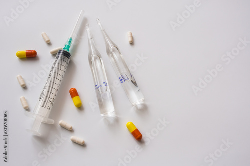Medical syringe, ampoules and pills for flu treatment Isolated on a white background. Copy space.