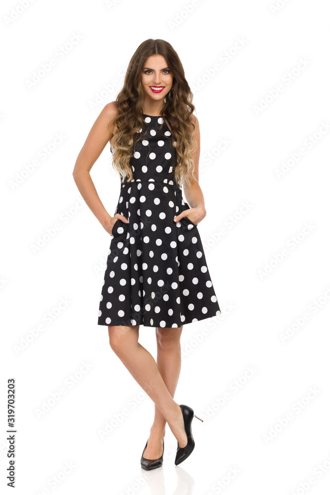 Relaxed Young Woman In Black Cocktail Dress In Polka Dots And High Heels Relaxed Young Woman In Black Cocktail Dress In Polka Dots And High Heels